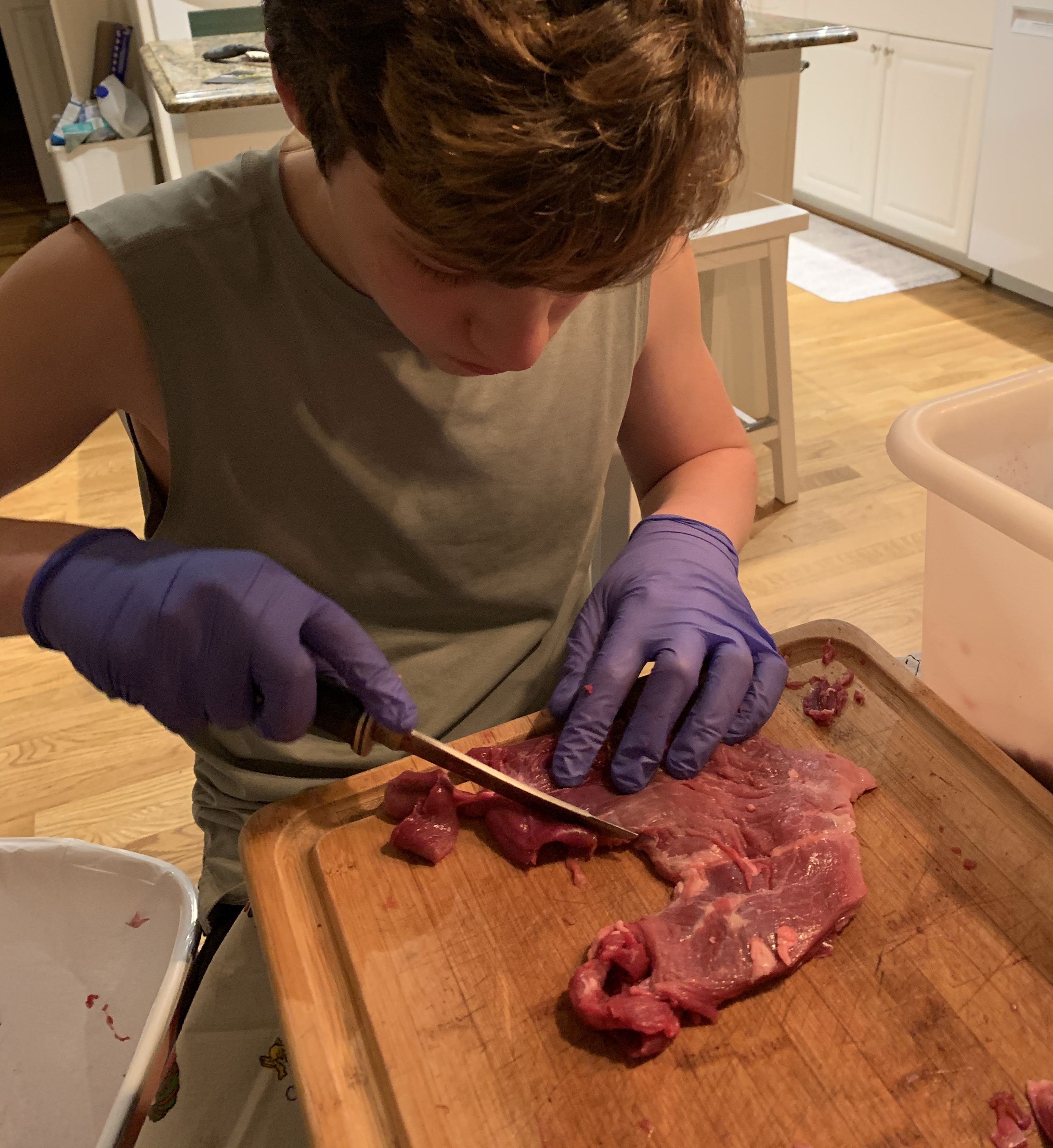 A boy skinning some meat